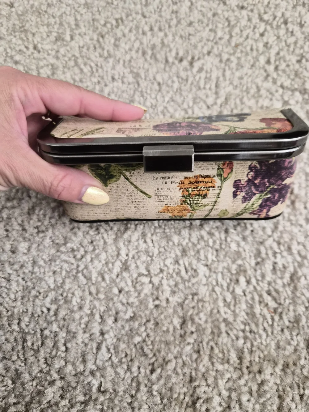 This is a Patricia Nash kiss-lock frame clutch with a built-in mirror